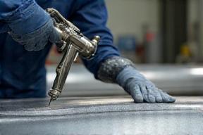 Tecnico applica rivestimento industriale su acciaio